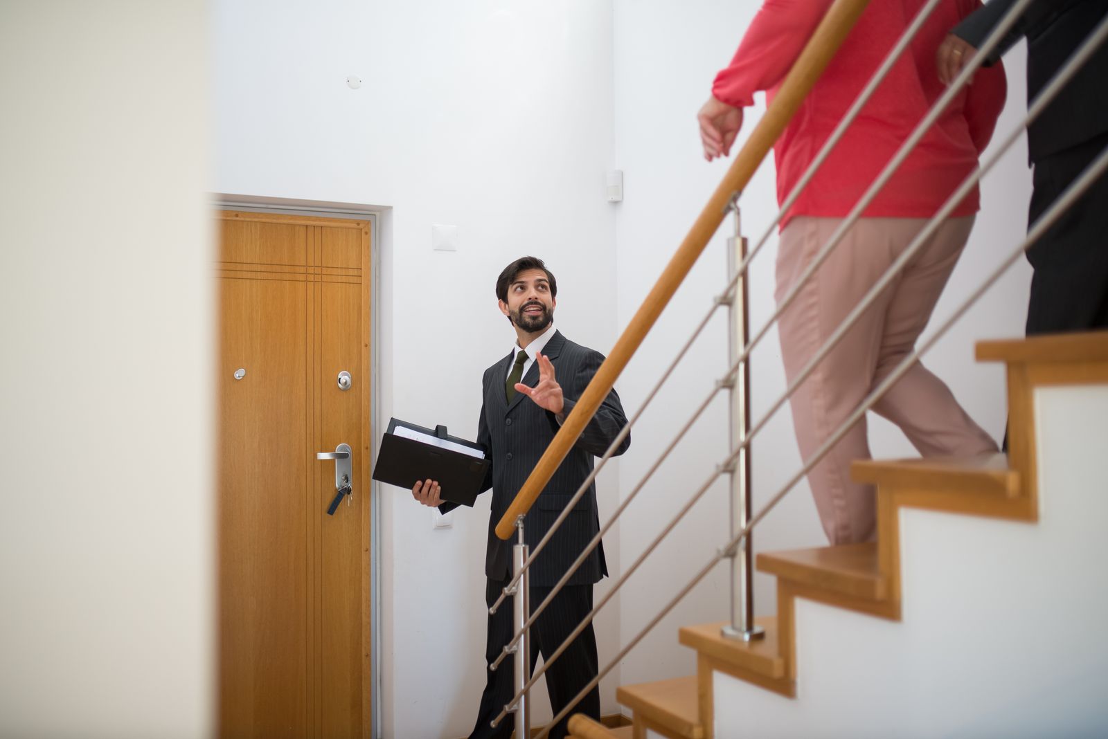 Meridian agent handing keys to new homeowners outside their house